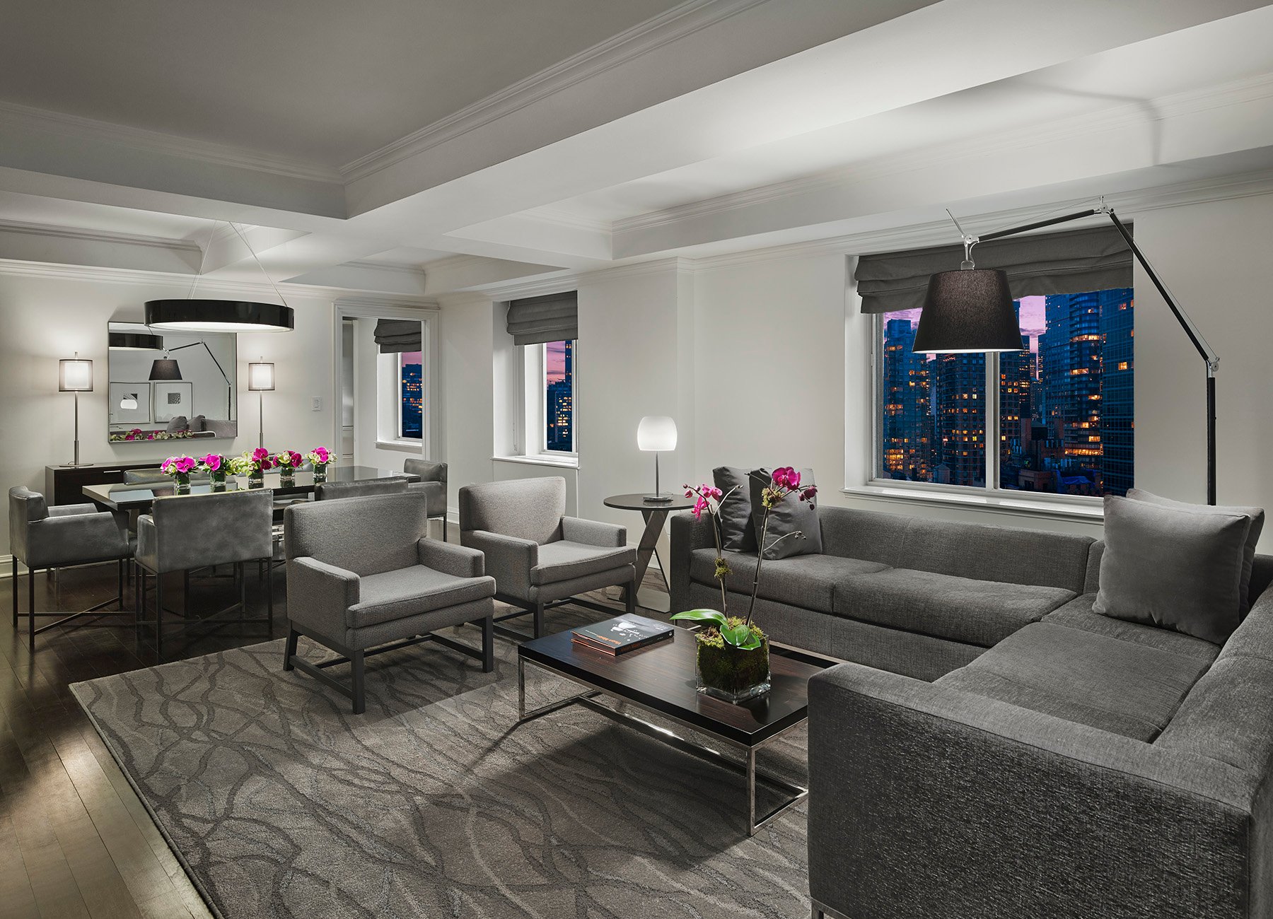 AKA Sutton Place furnished penthouse living room with gray couch and chairs on floor rug