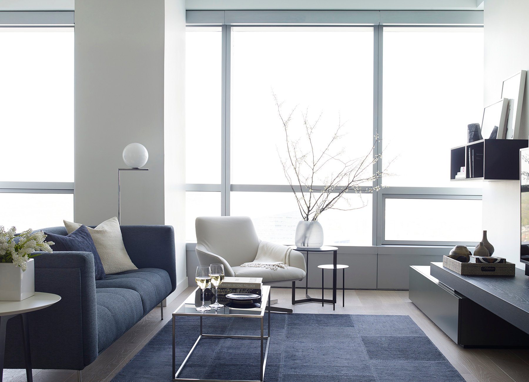 AKA University City living room with blue couch and Philadelphia city views through large windows 