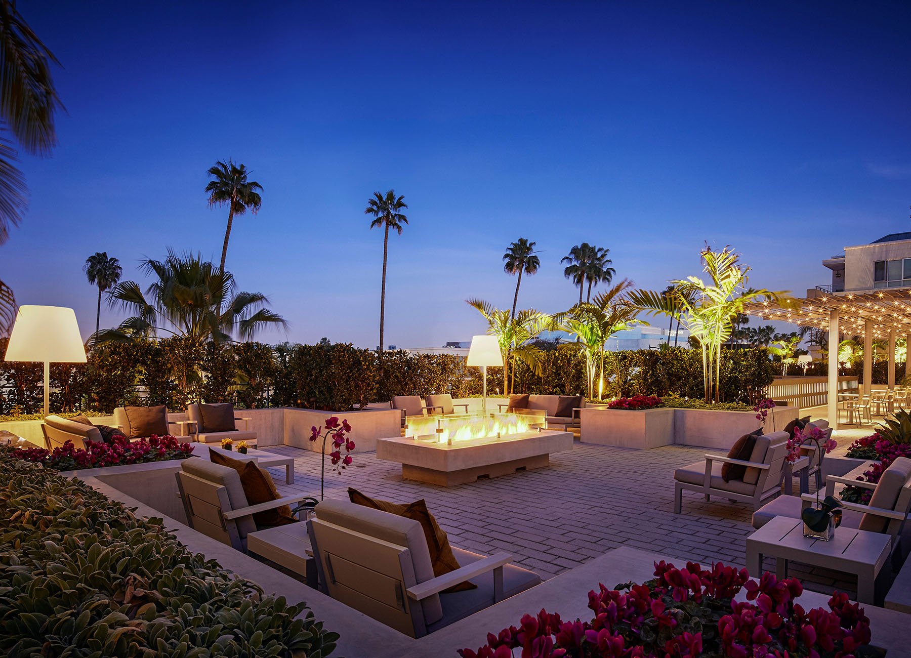 AKA Beverly Hills apartment terrace at dusk with firepit and bar