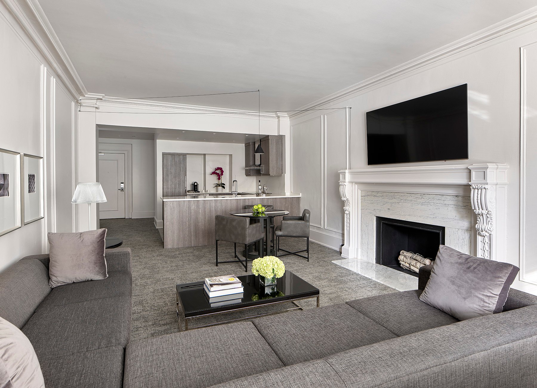 Suite with fireplace, living room with gray furniture, and open kitchen