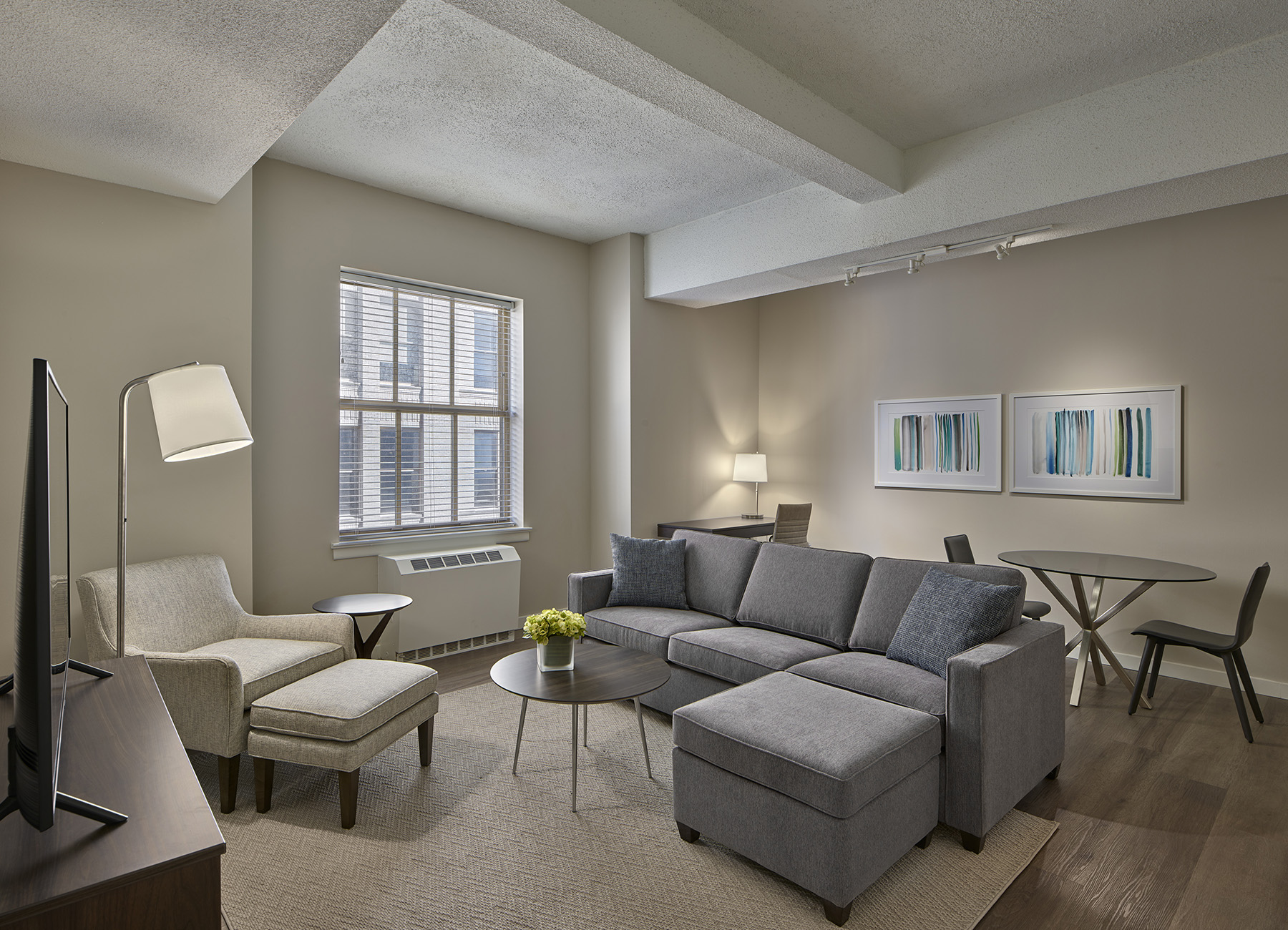 The Franklin Residences furnished Philadelphia apartment living room with gray furniture, high ceilings, desk and table