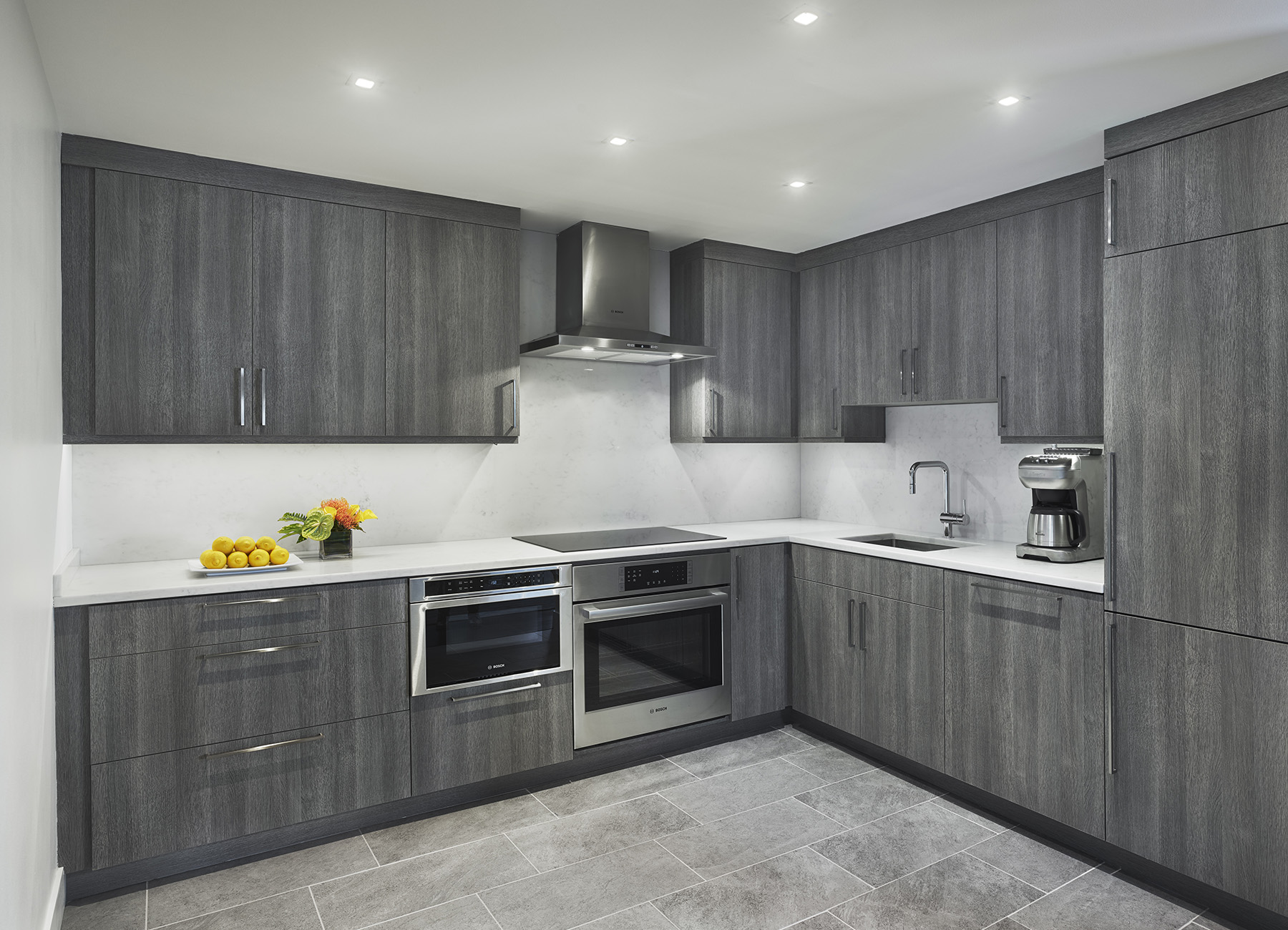 The Franklin Residences large Philadelphia penthouse kitchen with gray wood cabinets and white countertops