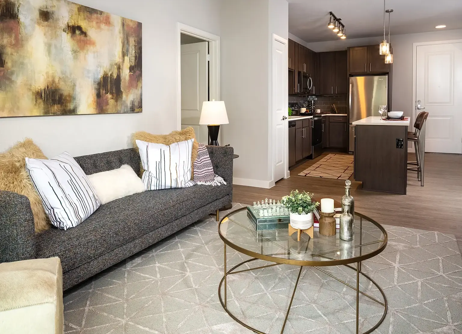 Living room with sofa, coffee table, and open kitchen in AVE Austin furnished apartment. 