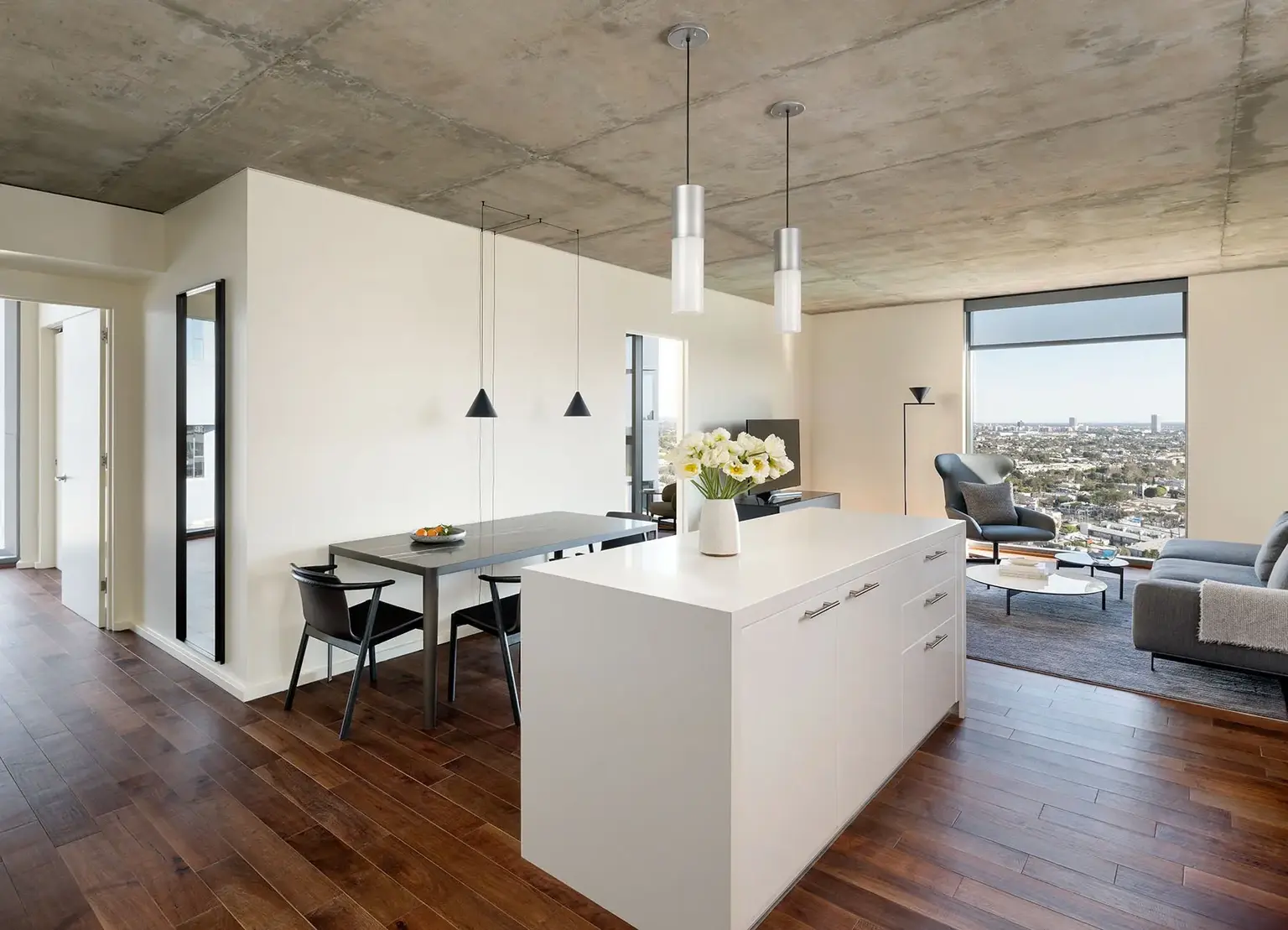AKA West Hollywood apartment kitchen island with living room and large window behind