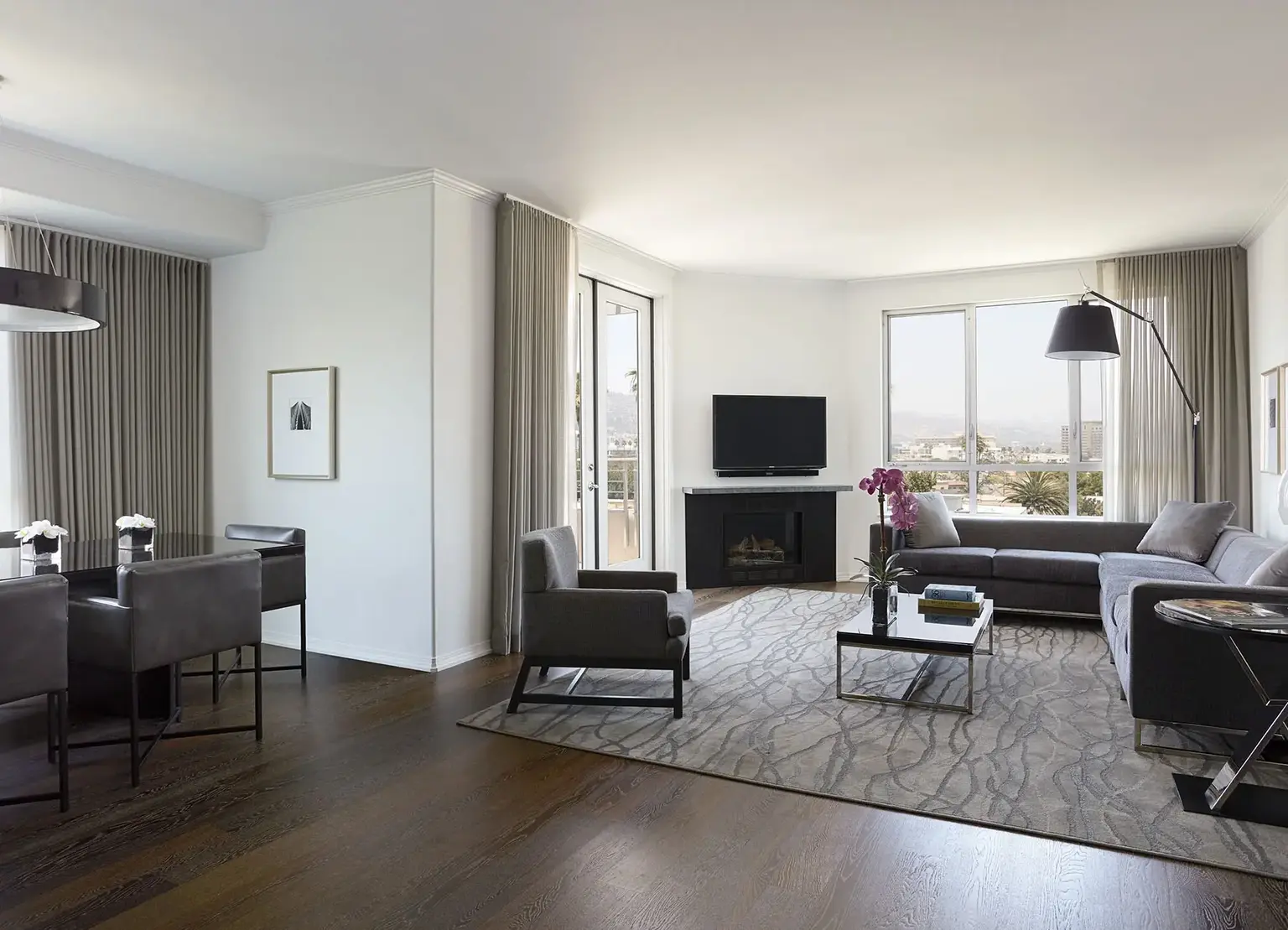 AKA Beverly Hills penthouse living room with couch, rug, tv, and city view 