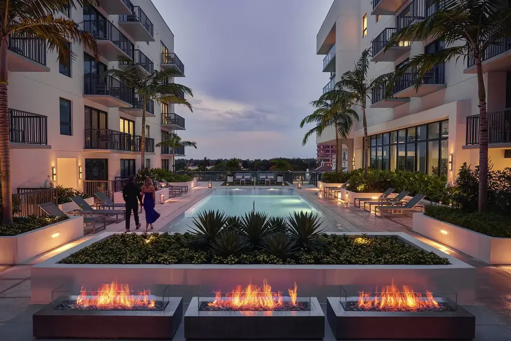 AKA West Palm Outdoor Pool with fireplaces at sunset