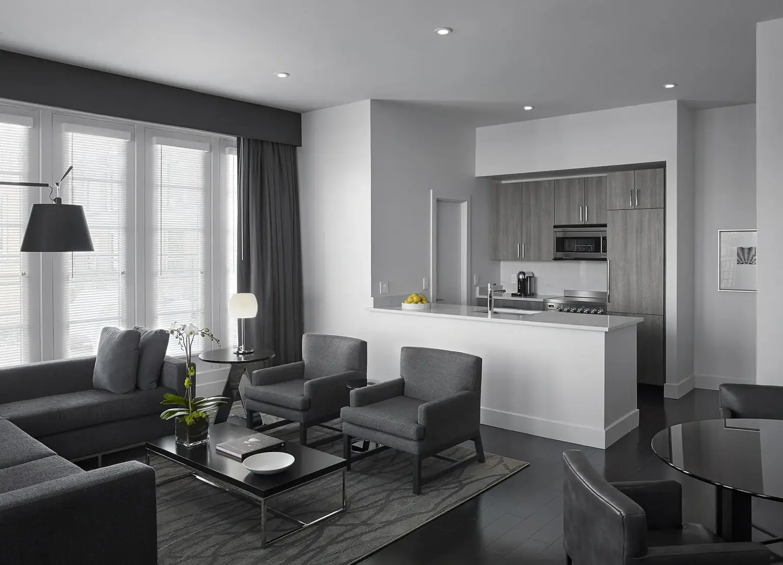 AKA White House apartment living room with gray couch and kitchen with white finishes