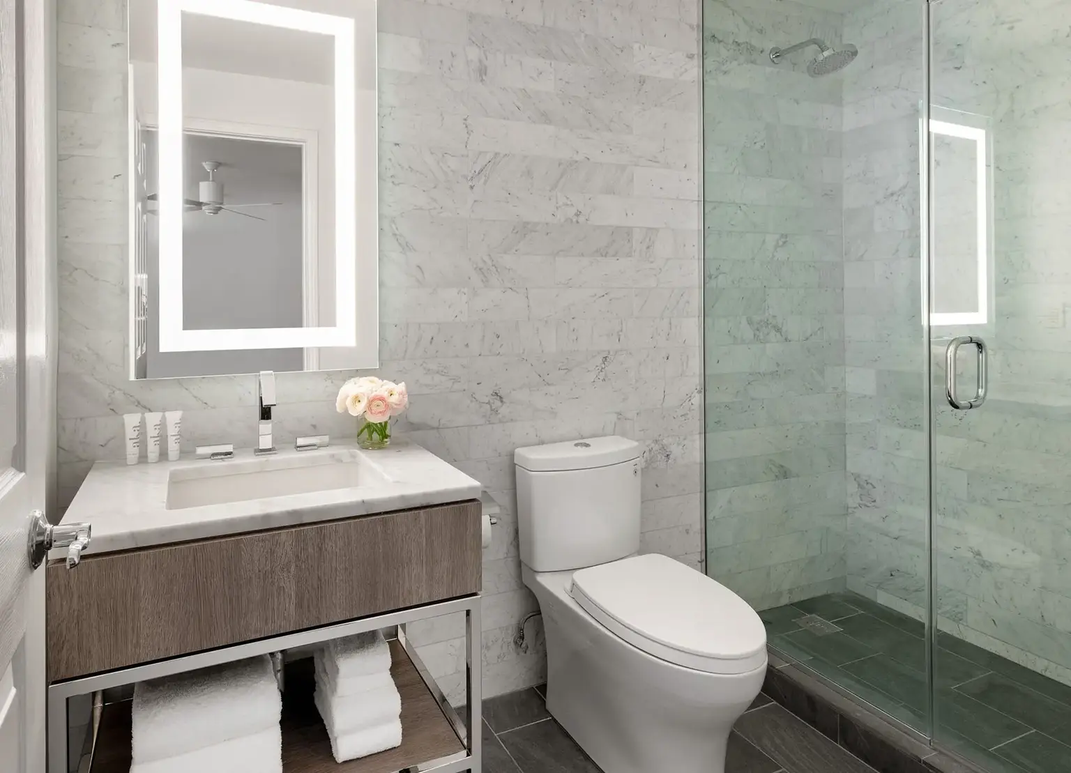 AKA Beverly Hills townhouse bathroom with lighted mirror and marble glass shower