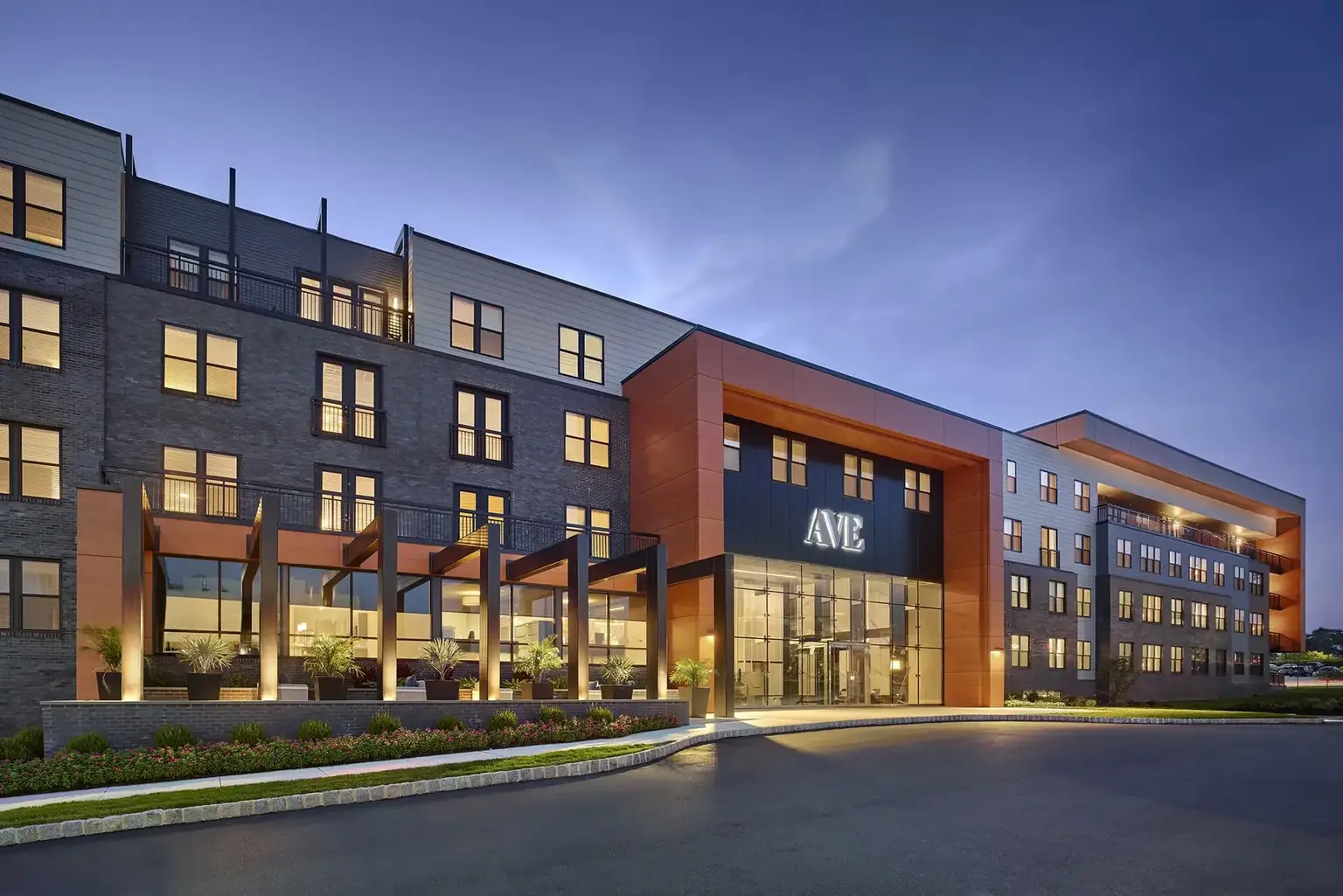 AVE King of Prussia exterior of modern mid-rise apartment building at dusk