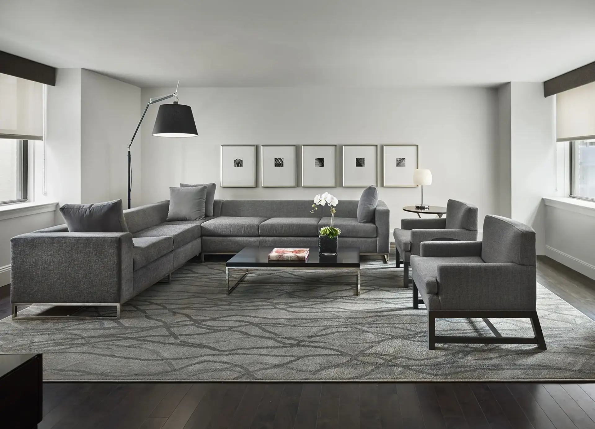 AKA Central Park furnished apartment living room with gray couch and chairs on floor rug