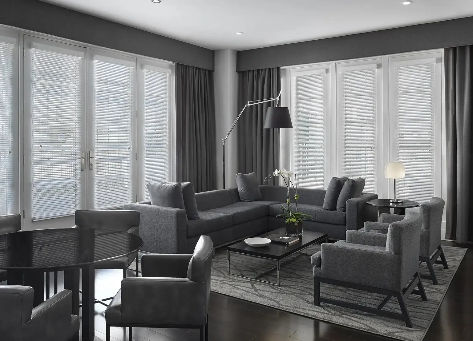 AKA White House apartment living room with gray furniture, large windows, and gray curtains