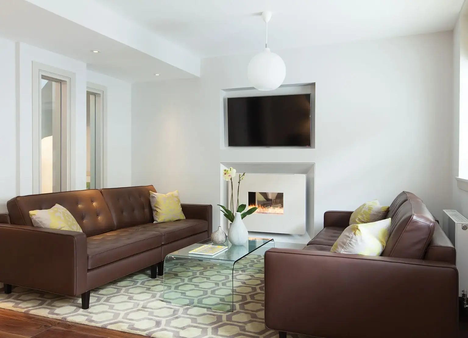 AKA Marylebone furnished apartment living room with two facing couches, fireplace and television
