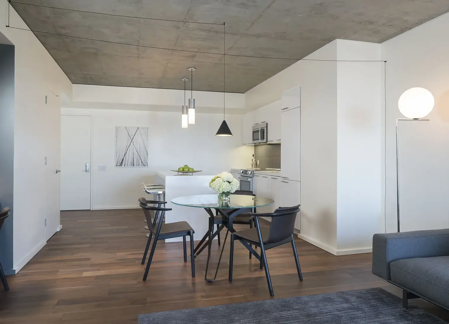 AKA West Hollywood apartment kitchen with wood floors, round dining table, and white cabinetry