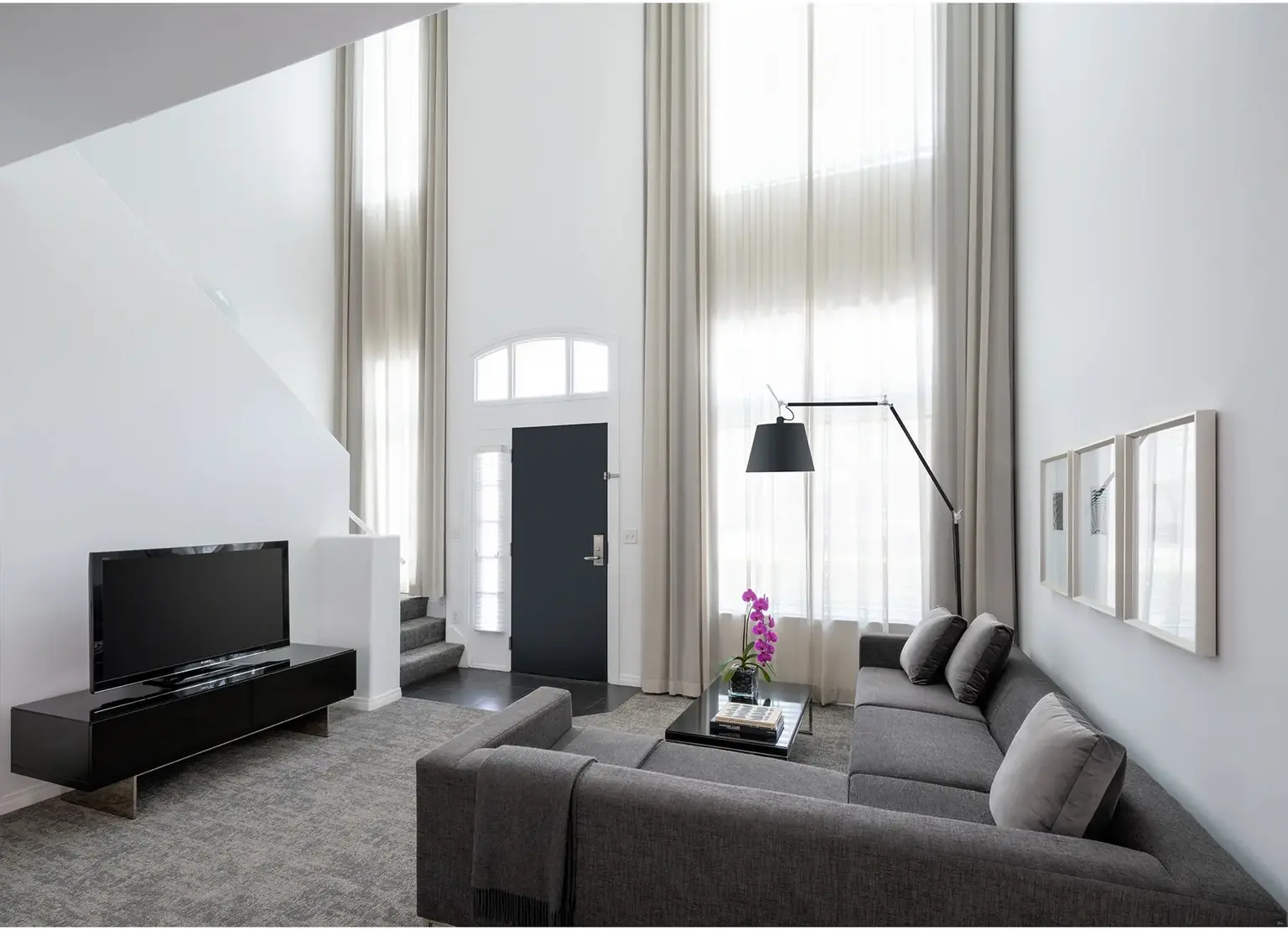 AKA Beverly Hills townhouse double height entry with couch and tv