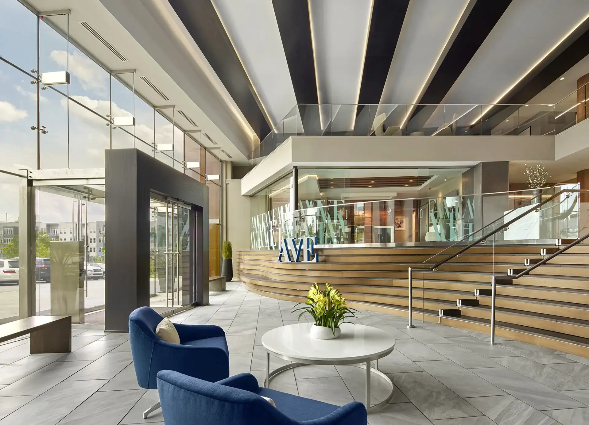 AVE King of Prussia apartment building lobby with architectural stairs leading to leasing and amenities. Large AVE sign in front