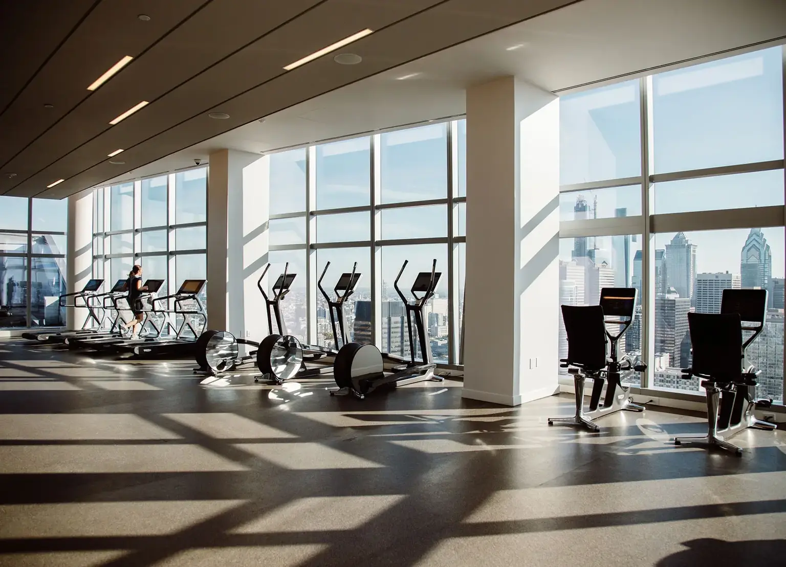 AKA University City fitness center with cardio equipment overlooking the Philadelphia skyline