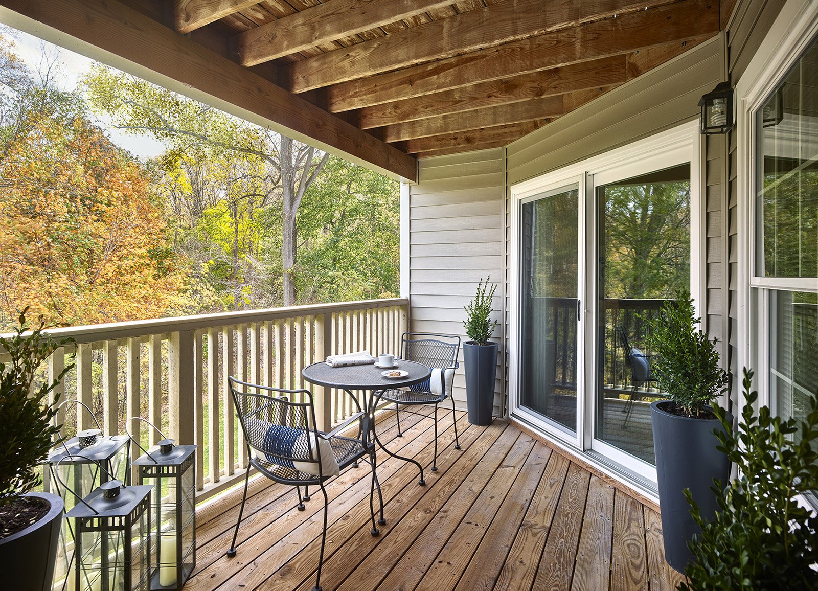 Wooden balcony with table looking out to changing leaves in forest