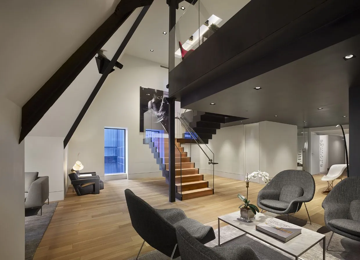 AKA Times Square penthouse lounge with seating options, open staircase, and wooden accents